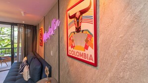 A room with a sofa, a neon sign, and a framed poster of a bull. - Ayamonte - 105b in Medell n (Medellín)