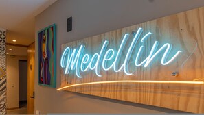 A hotel reception area with a neon sign spelling 'Modellin' on the wall. - Ayamonte - 105a in Medell n (Medellín)