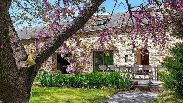 A stone building with a garden path leading to a table and chairs. - Grand Le Jeanneau Cottage with Spa, Peaceful Nature Retreat for 15 Guests (Vallons-de-l'Erdre)