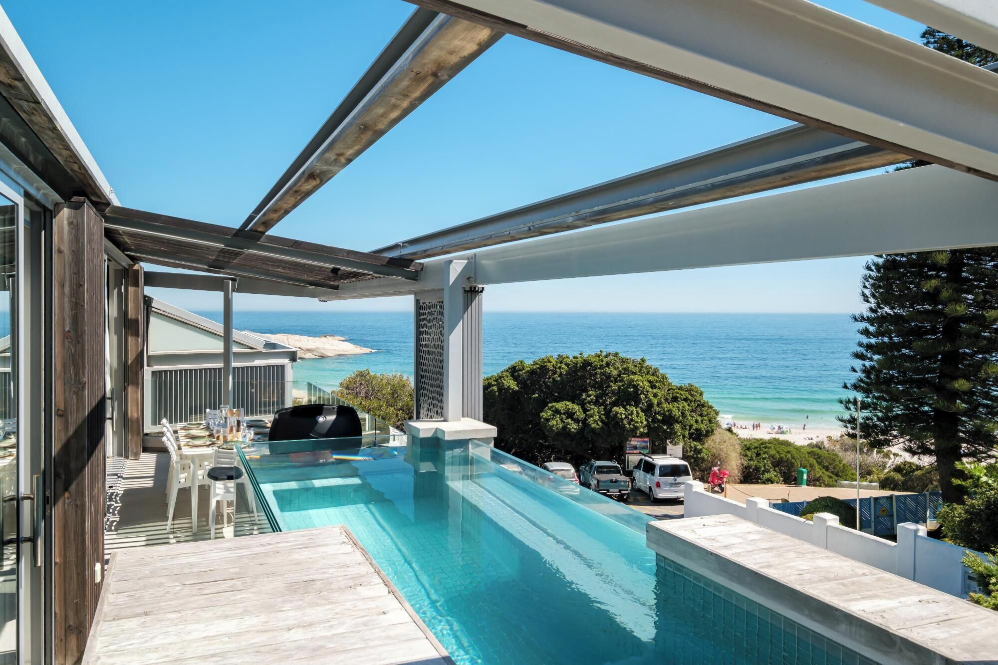 A rooftop pool with a view of the ocean and beach.