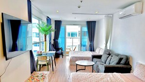 A modern hotel room with a bed, sofa, dining table, and a large window. - SKYHOME 2 GIUONG DOI A9 (Ho Chi Minh City)