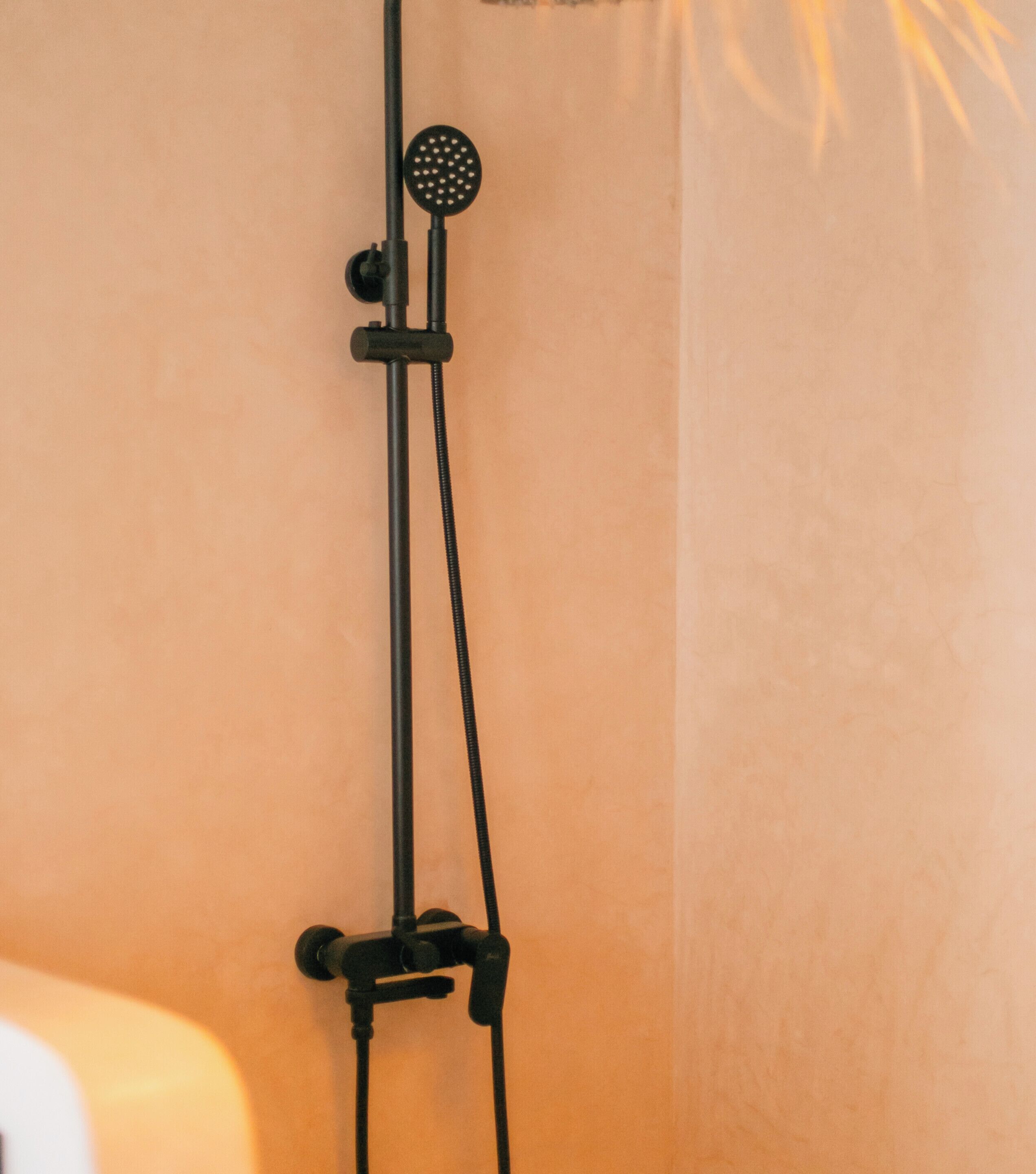 Une douche équipée d’un pommeau de douche à main et d’un appareil de massage à main.