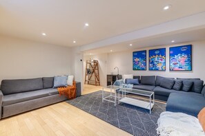 A modern living room with two sofas, a coffee table, and colorful artwork on the wall. - Grand Urban Retreat – Spacious 5BR Heart MTL (Montréal)