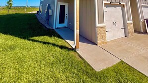 Ein zweistöckiges Haus mit Garage und überdachter Veranda, strahlend blauer Himmel.