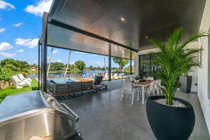 Un área exterior moderna con piscina, sillones de descanso y una mesa de comedor.