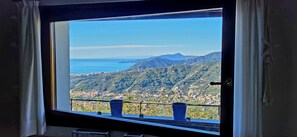 A window with a view of a coastal landscape, including mountains and a body of water. - Stone Country House 'Paradiso San Giacomo' with Sea View and Large Garden (Cogorno)