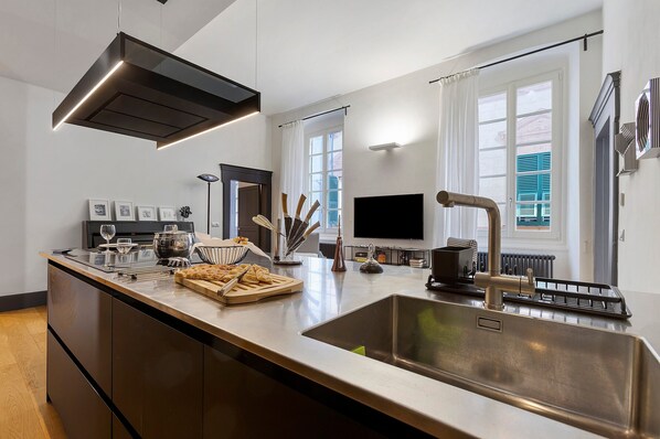 Una cocina moderna con una isla grande, electrodomésticos de acero inoxidable y un televisor de pantalla plana.