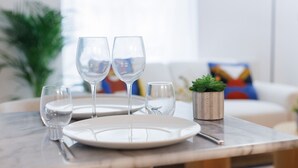 Un tavolo da pranzo con tre bicchieri da vino, un piatto e una piccola pianta in vaso.