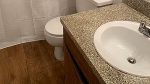 Ein Badezimmer mit Toilette, Waschbecken und einer Duschvorhang.