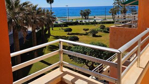 A balcony with a view of the sea, palm trees, and a parking area. - Apartment 'Duplex Jardines Del Mar' with Sea View, Wi-Fi and Air Conditioning (Salobreña)