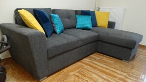 A grey sectional sofa with multiple cushions in various colors, positioned on a marble floor. - Seizani Athens Stay-1,6 km From Panathenaic Stadium (Kaisariani)