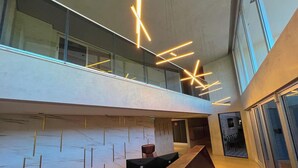 Un intérieur moderne avec une rambarde en verre, un coin salon et un escalier.