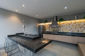 Eine moderne Küche mit einer zentralen Kochinsel, integrierten Geräten und einer geometrischen Spritzschutzwand.