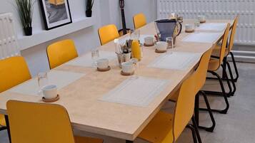 A conference room with a long table, yellow chairs, and a whiteboard.