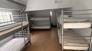 A dormitory room with bunk beds, a wooden floor, and a small window. - Lemon Apartment (Schaerbeek)