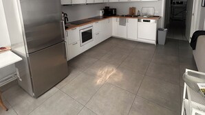 A modern kitchen with a stainless steel refrigerator, white cabinets, a microwave, and a sink. - Lemon Apartment (Schaerbeek)