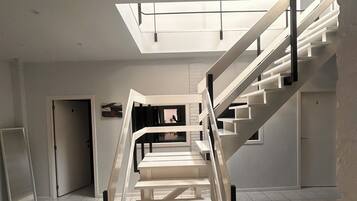 Un intérieur moderne avec un escalier menant à une lucarne.