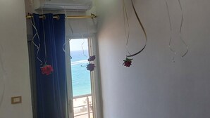 Een kamer met een bed, ballonnen en uitzicht op zee.