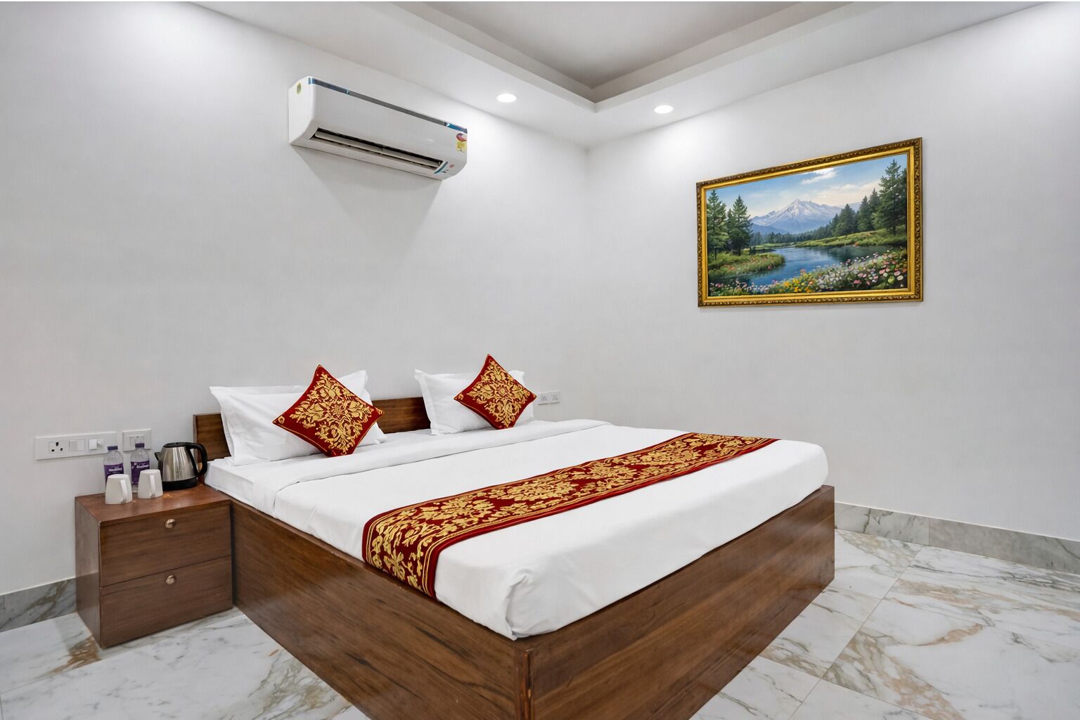 Ein Hotelzimmer mit Bett, Nachttisch, Klimaanlage und einem Bild an der Wand.