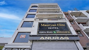 Ein mehrstöckiges Hotel mit einem Schild für 'Mauryan Elite Hotel' an der Fassade.