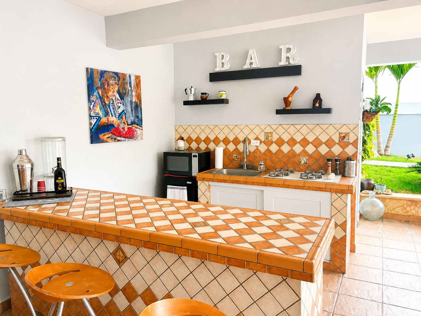 Une cuisine avec un coin bar, un tableau et une vue sur l’extérieur.
