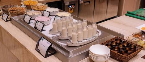 A buffet setup with various food items and condiments.