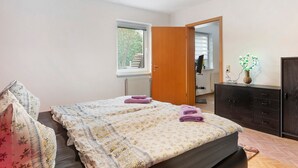 A bedroom with a bed, a window, a dresser, and a mirror. - Holiday Home 'Ferienwohnung Sehr Ruhig' with Private Garden and Wi-Fi (Pößneck)