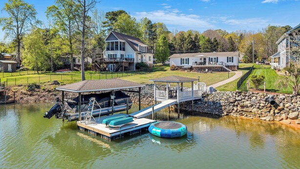 A lakeside property with a dock, a floating platform, and a house with a deck. - Lakefront Retreat w/ Boat Dock, Hot Tub & Large Game Room!  Sleeps 10 (Denver)