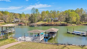 A lake with docks, a gazebo, and a small boat. - Lakefront Retreat w/ Boat Dock, Hot Tub & Large Game Room!  Sleeps 10 (Denver)