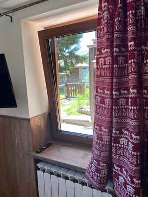 A room with a window, a radiator, and a remote control on a wooden ledge. - Apartment 'L’angolo del paradiso Gimillan' with Mountain View and Private Garden (Gimillan)