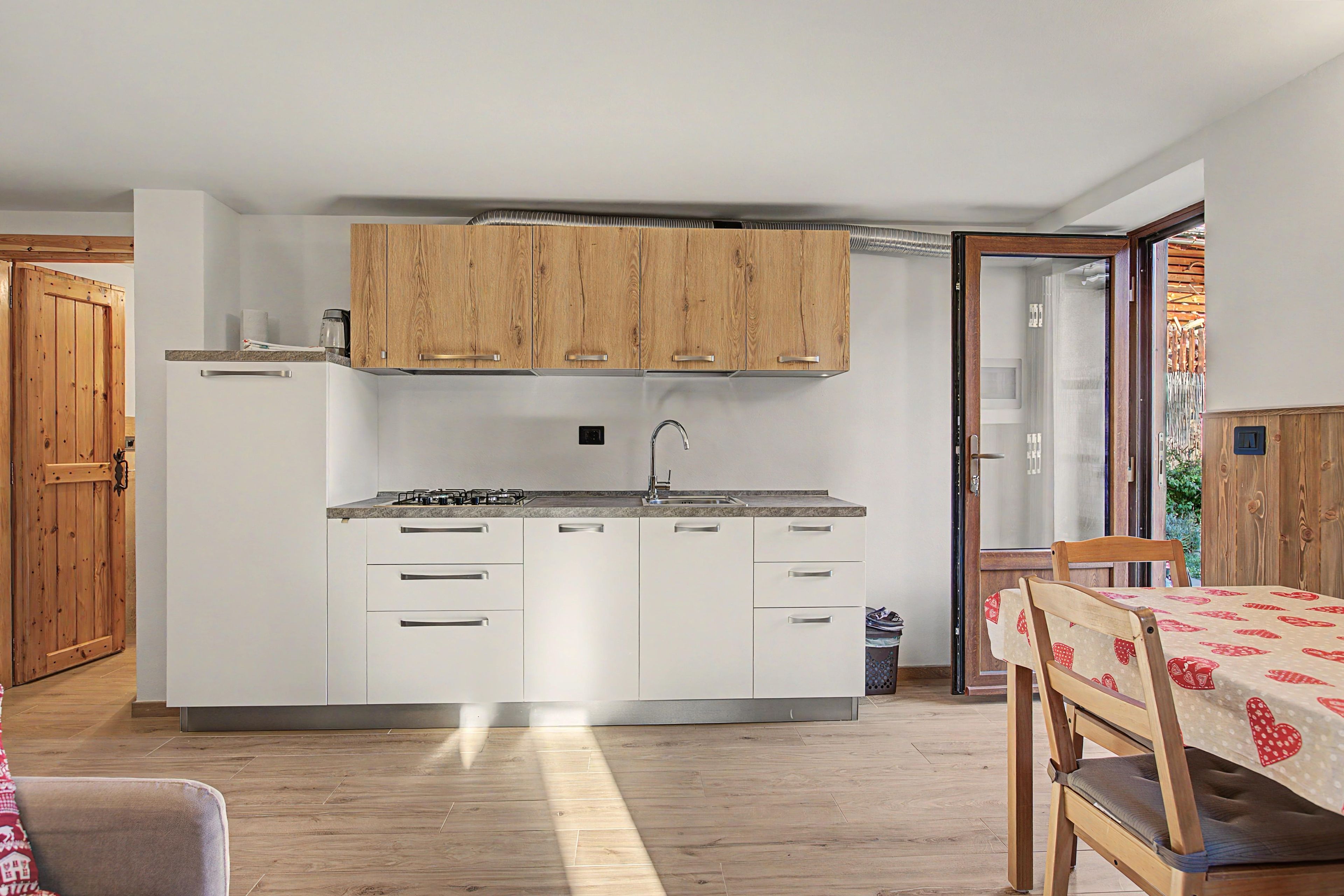 A compact kitchen with wooden cabinets, a gas stove, and a sink.