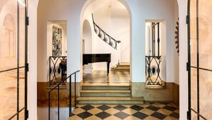 A grand staircase with a checkered floor, leading to a piano in a spacious room. - Par056 - Mansion-Style Apartment by Parc Monceau (Paris)