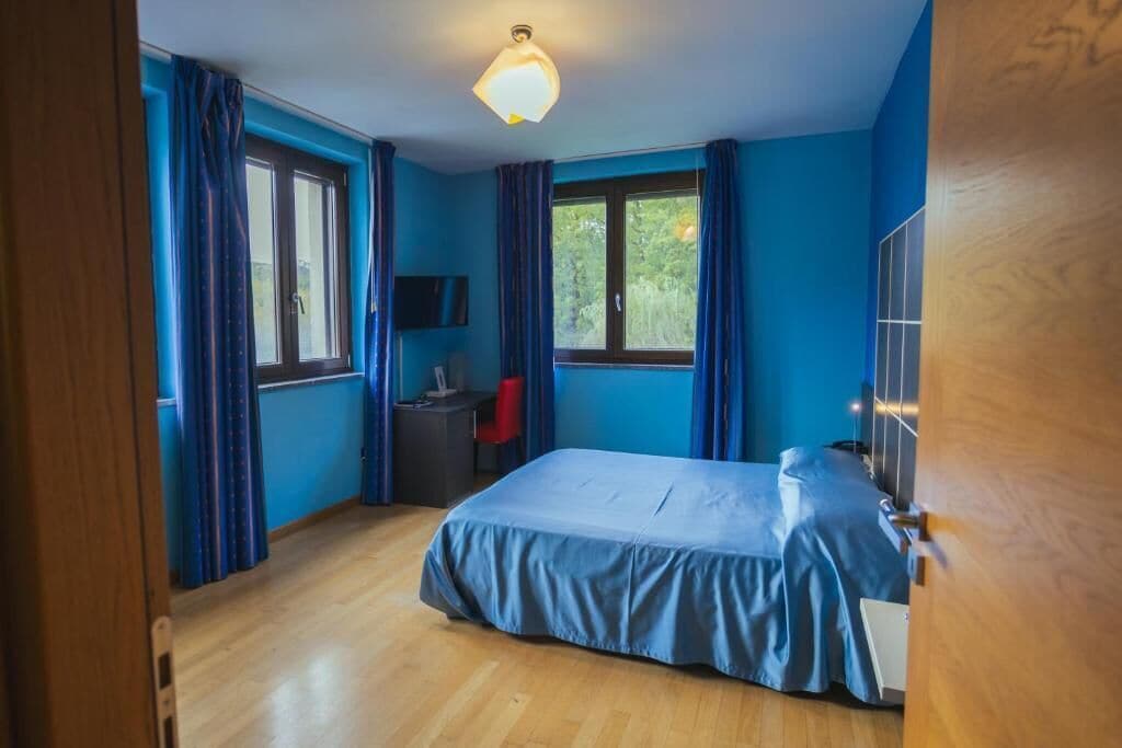 Un dormitorio con cama, escritorio y silla.
