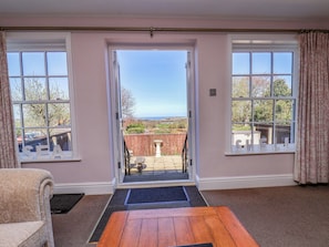 A room with a view to the sea, a wooden table, and a bench. - Annie's Place (Whitby)