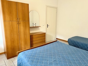 Ein Schlafzimmer mit Bett, Kleiderschrank, Schminktisch und Spiegel.