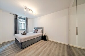 A modern bedroom with a bed, bedside table, and a wardrobe. - Two ensuite doubles, walk to Manchester city centre (Manchester)