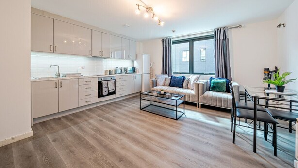 Een modern appartement met een keuken, eethoek en woonkamer.