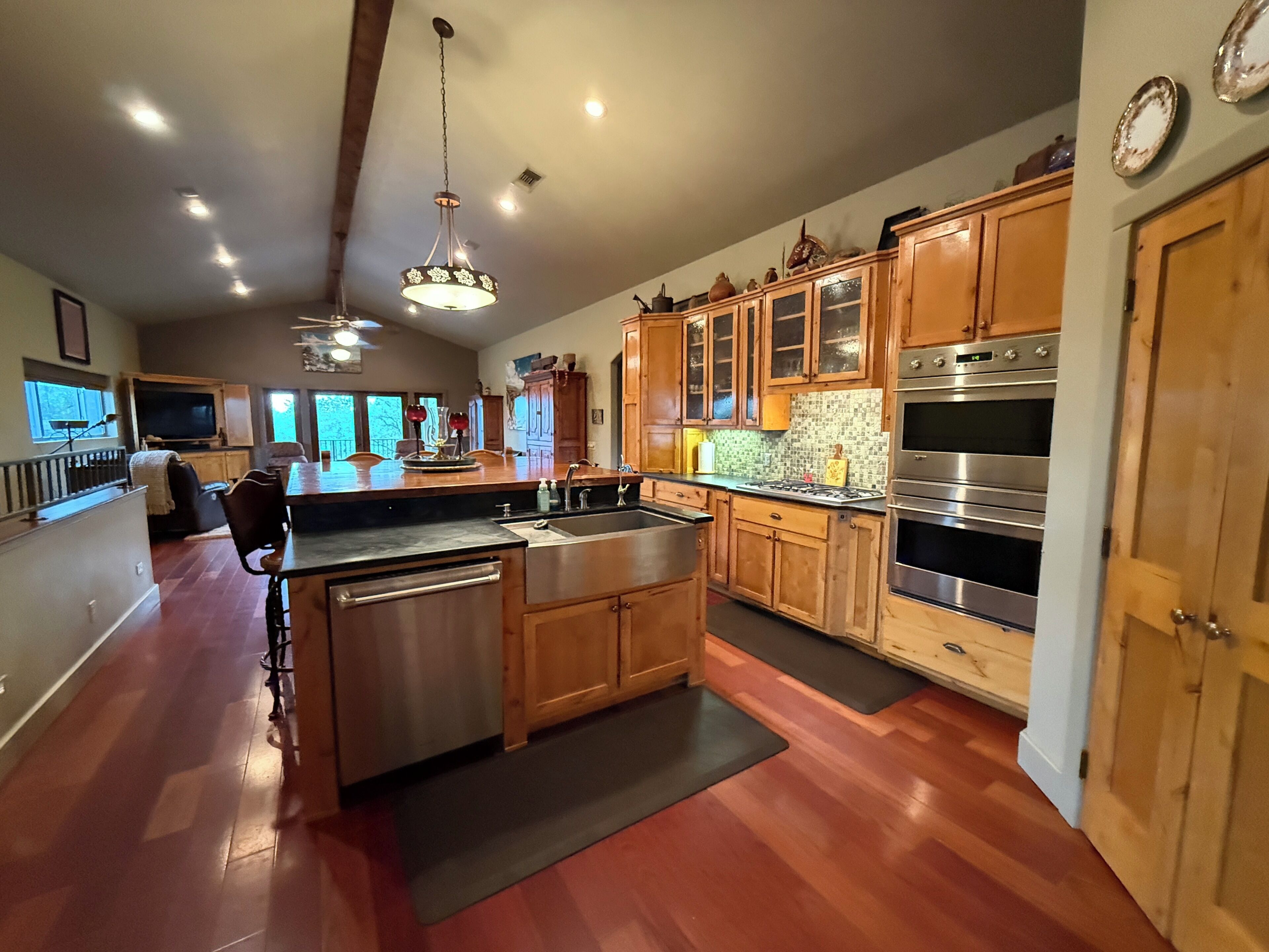 A spacious kitchen with wooden cabinets, a stainless steel dishwasher, and a large island.