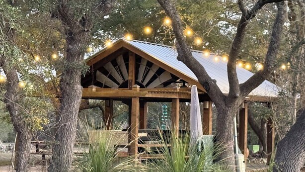 A wooden pavilion with a metal roof, surrounded by trees and plants. - Hill Country Escape near Wineries, Mae’s Ridge Wedding Venue & P. Falls State Pk (Johnson City)