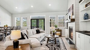 A spacious living room with a sofa, coffee table, and fireplace.