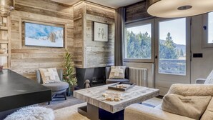 Un soggiorno moderno con camino, ampie finestre e rivestimenti in legno.