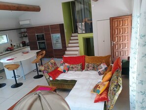 Uma sala de estar moderna com sofá, área de refeições e cozinha.