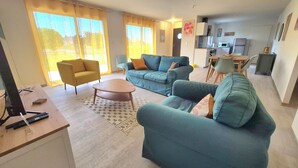 Ein Wohnzimmer mit zwei Sofas, einem Couchtisch und einem Essbereich mit Tisch und Stühlen.