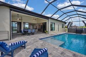 Ein Innenpool mit überdachter Terrasse, inklusive Liegestühlen und Esstisch.