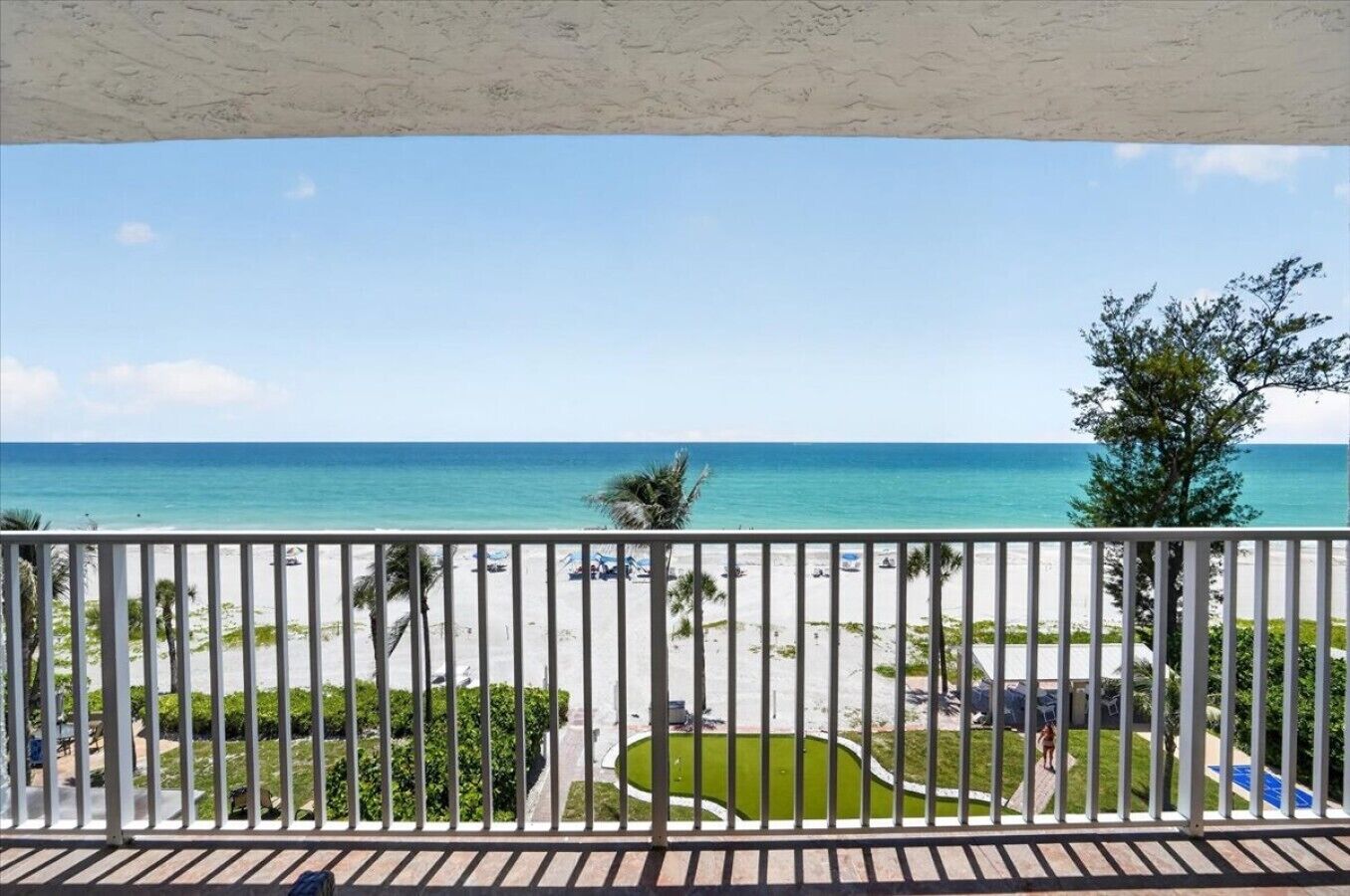 Un balcón con vista a la playa y al océano.