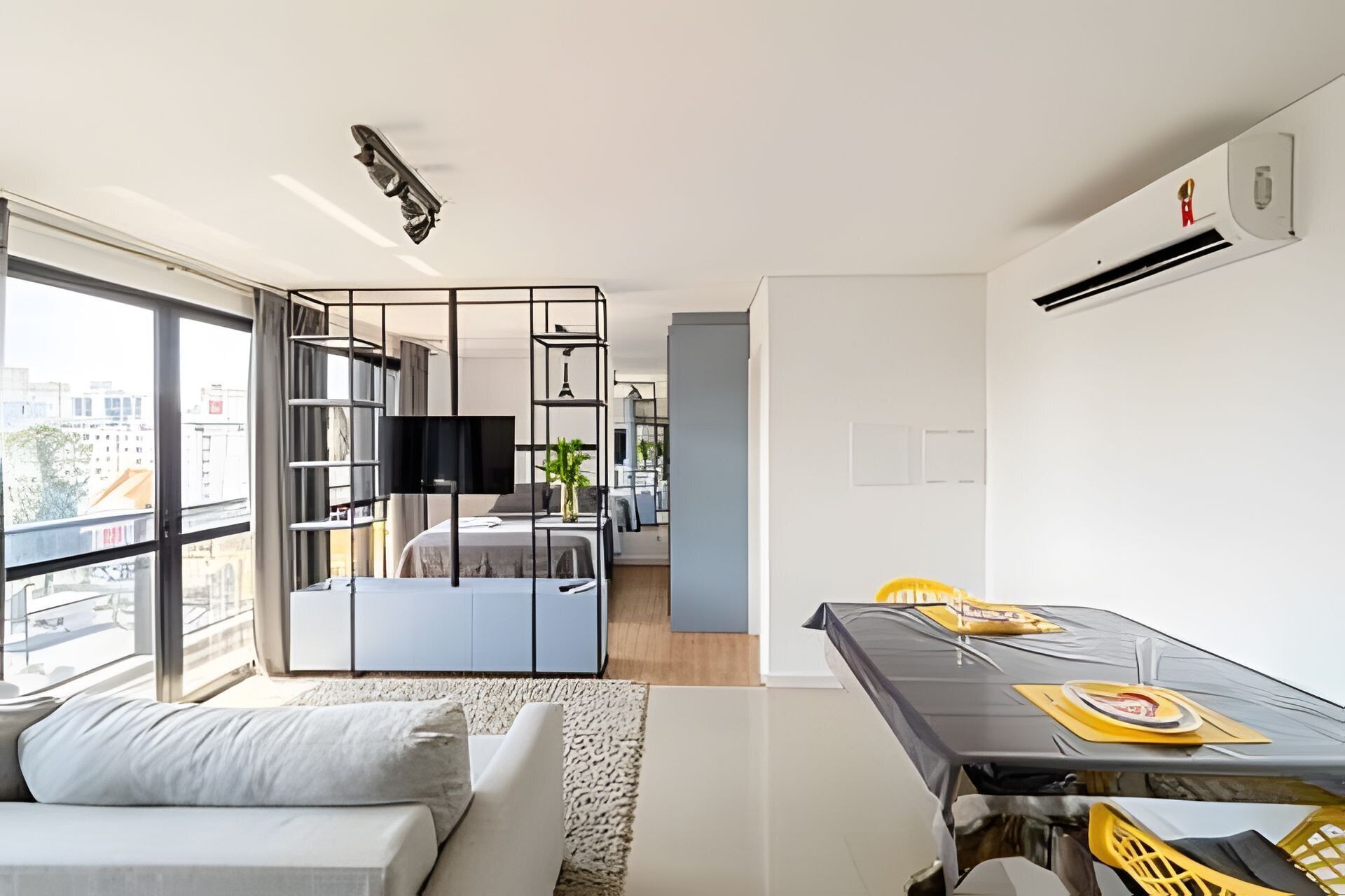 Un apartamento moderno con balcón, zona de comedor y sala de estar.