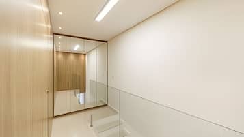 Ein modernes Interieur mit Holztür, Glasgeländer und klarem, minimalistischem Design.