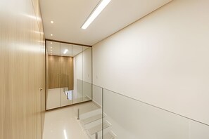A modern interior with a wooden door, a glass railing, and a clean, minimalist design. - Flipchave - Apartamentos Highline design (Joinville)