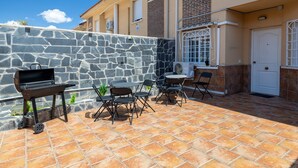 A patio with a grill, chairs, and a stone wall. - Semi-detached chalet for up to 12 guests, Pool, BBQ (Loeches)