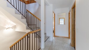 A staircase with wooden handrails and a light fixture on the wall. - Semi-detached chalet for up to 12 guests, Pool, BBQ (Loeches)